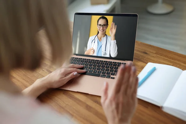 Medico femminile sullo schermo del computer portatile che agita la mano al paziente malato — Foto Stock