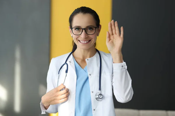 Sonriente doctora graciosamente sostiene su mano. —  Fotos de Stock