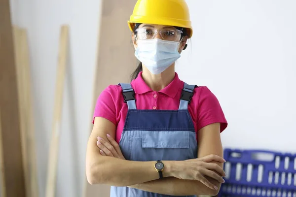 Orvosi maszkot viselő védősisakos nő az építkezésen — Stock Fotó