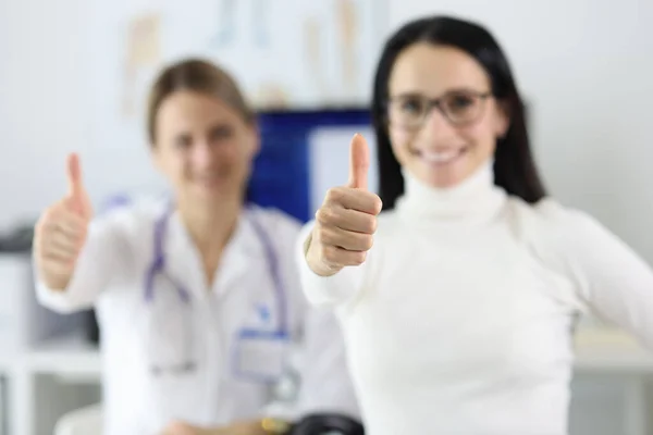 Mujer médico y paciente sonrisa y mantenga los pulgares hacia arriba. —  Fotos de Stock