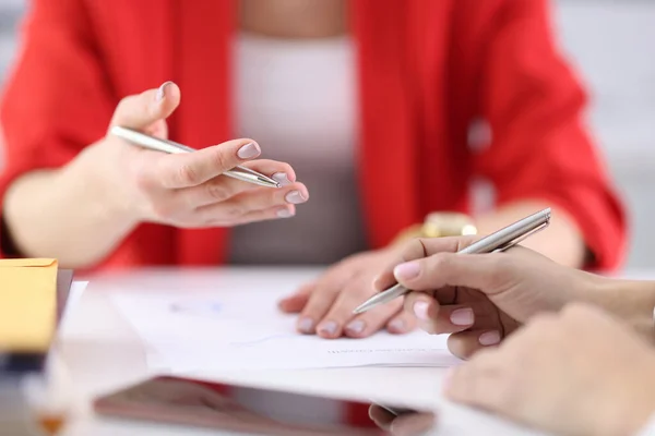 Vrouwelijke handen houden pennen en documenten boven de werktafel. — Stockfoto