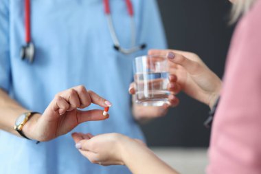 Doktor hastaya ilaç ve bir bardak su verdi..