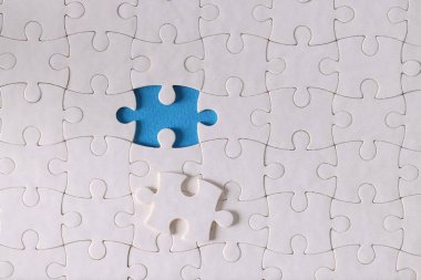 Tek parça olmayan beyaz yapboz parçaları masanın üzerinde.