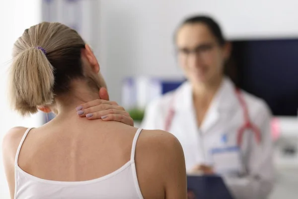 Жінка скаржиться на біль в шиї лікаря . — стокове фото