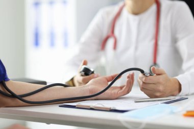 Doktor terapisti hastaların basıncını yakından ölçüyor.