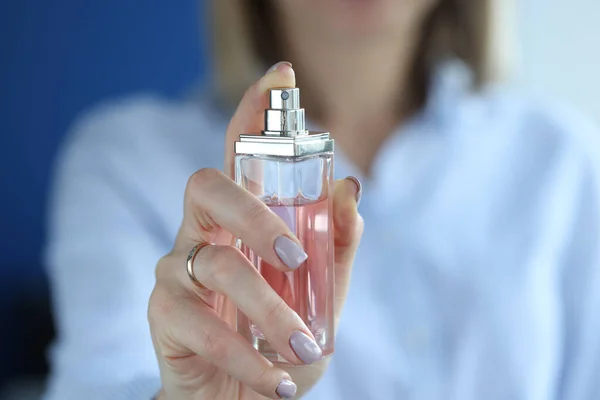 Recipiente de vidrio con perfume está en manos de las mujeres. — Foto de Stock