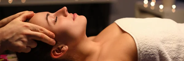 Девушка делает расслабляющий массаж головы в салоне красоты — стоковое фото