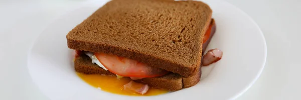 A tányéron van szendvics, fekete kenyér kolbásszal. — Stock Fotó