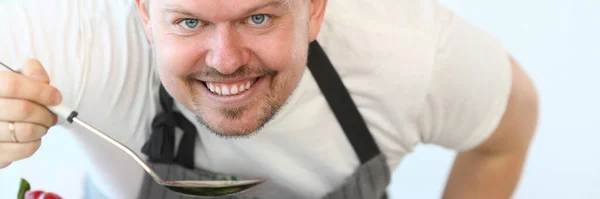 Retrato de homem bonito que cozinha sopa — Fotografia de Stock