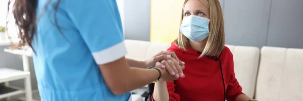 Médico en uniforme sostiene la mano de mujer joven enferma en retrato de silla de ruedas —  Fotos de Stock