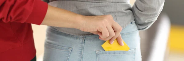 女性の手置くcondomで別の女性のジーンズポケットクローズアップ. — ストック写真
