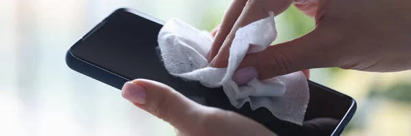 Smartphone in de hand, die wordt afgeveegd met een vochtige doek — Stockfoto