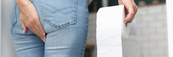 Woman holds hand on priest in other hand toilet paper and stands opposite the humiliated