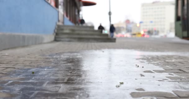 Человек в зимнем платье скользит по тротуару со льдом крупным планом — стоковое видео