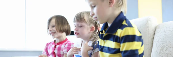 Tre bambini seduti sul divano in camera. — Foto Stock