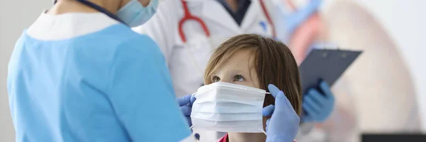 医者で青スーツと保護マスク置く保護マスク上の女の子顔. — ストック写真