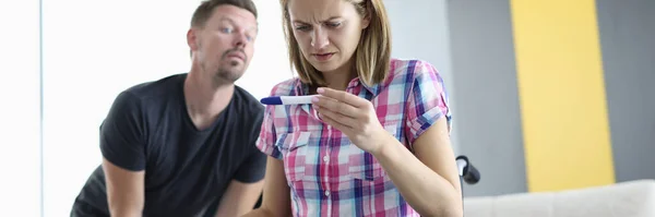 車椅子の女性は男の目の後ろから妊娠検査をよく見る — ストック写真