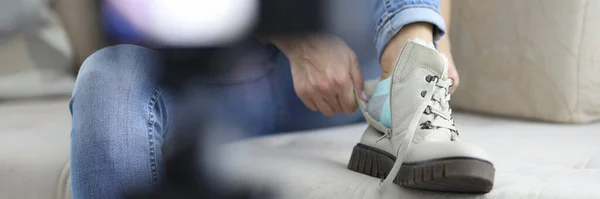 Vrouw zet op warme laars met haar voet op de bank in de voorkant van camera close-up — Stockfoto