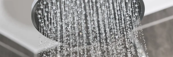 Gros plan sur les débits d'eau dans les petits jets de pluie métallique douche dans la salle de bain — Photo