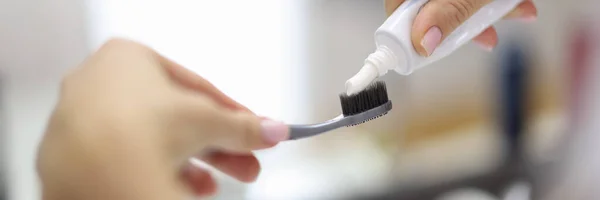 Samičí ruční mačkání zubní pasty z trubice na zblízka zubní kartáček — Stock fotografie