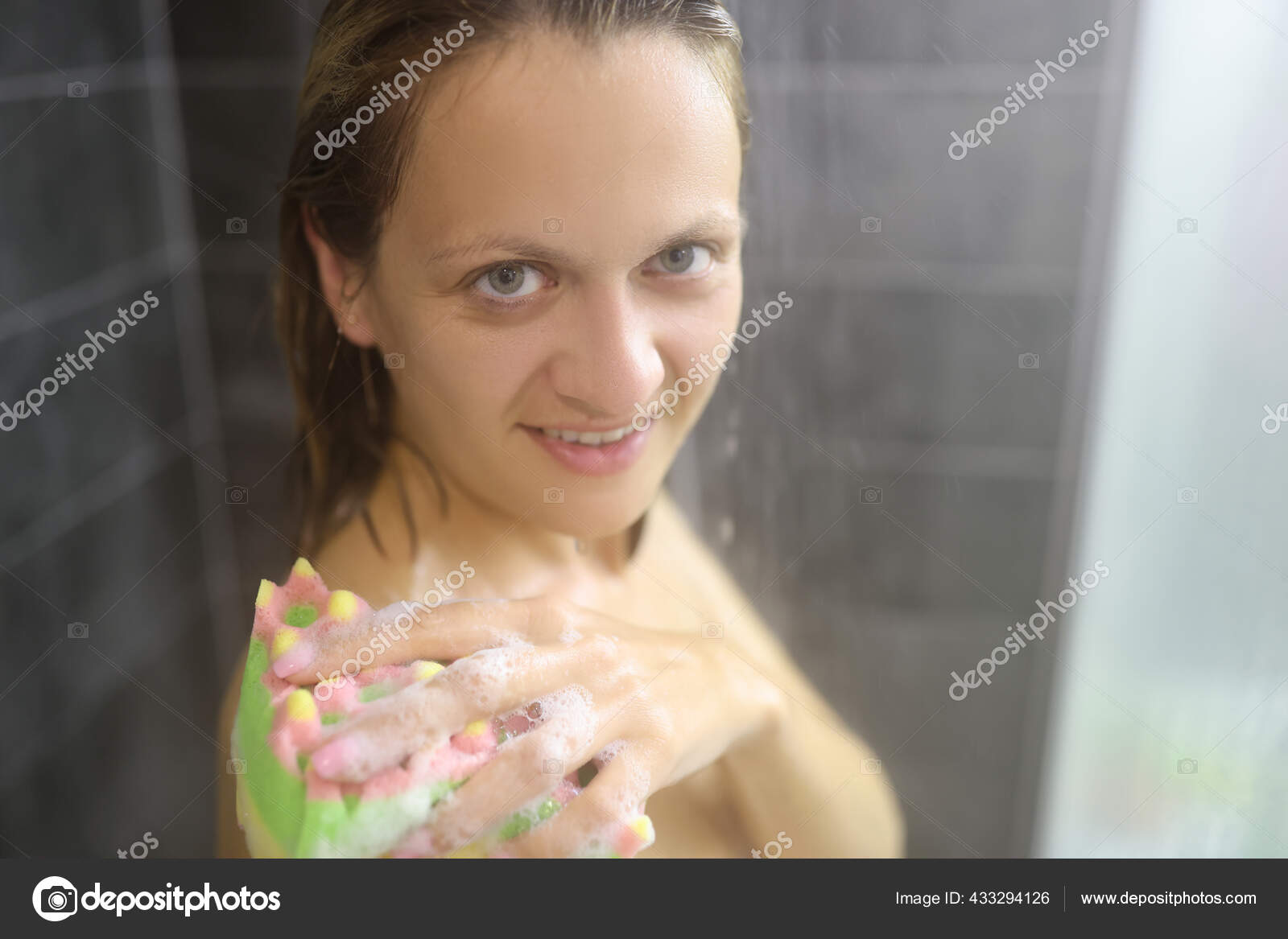Naked woman in shower stall wash body with sponge with foam. — Stock