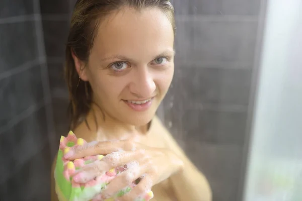 Meztelen nő zuhany istállóban mosás test szivaccsal hab. — Stock Fotó