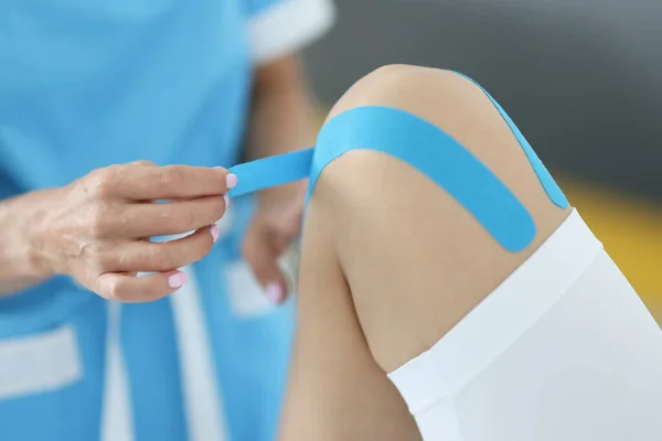 Lékař lepí pásky pacienta zmírnit bolesti kloubů. — Stock fotografie