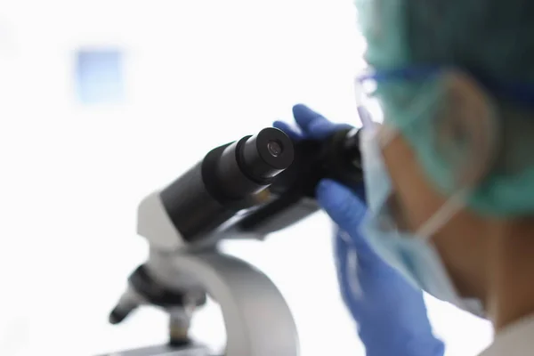 Médecin examine la mutation des virus et des bactéries au microscope en laboratoire. — Photo