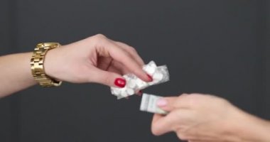 Kadın eli para dağıtıyor ve bir paket hap alıyor. 4K film.