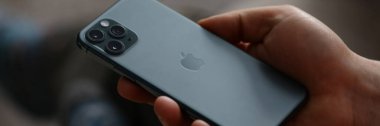 Bir adam yeni model bir Apple iphone 'u yakından tutuyor.