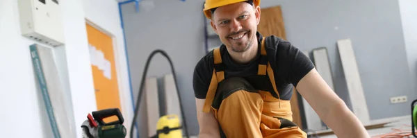 Homem construtor detém placa laminado em suas mãos — Fotografia de Stock