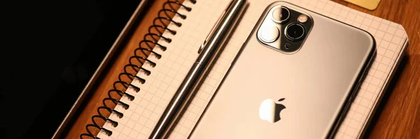 Νέο μοντέλο Apple iphone βρίσκεται στο σημειωματάριο με στυλό διαρκείας στο γραφείο — Φωτογραφία Αρχείου