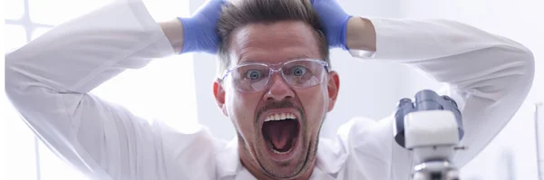 Hombre con gafas y guantes de goma se saca el pelo de la cabeza en un retrato químico de laboratorio —  Fotos de Stock