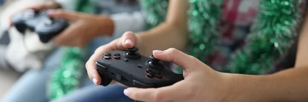 Duas mulheres com ouropel ao pescoço estão segurando joysticks close-up — Fotografia de Stock