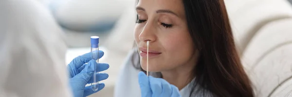 Médico assistente de laboratório em terno de proteção leva cotonete do nariz do paciente doente em casa — Fotografia de Stock