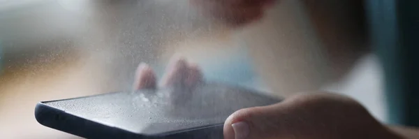 Telefone celular em mãos de mulher é tratado com spray anti-séptico close-up — Fotografia de Stock