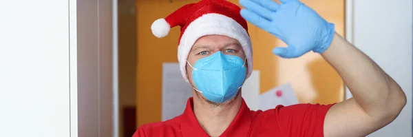 El hombre en respirador azul y guantes sostienen la caja con regalo y saludan de la onda. — Foto de Stock