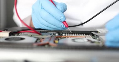 Eldivenli eller, masanın üzerinde elektronik bir cihaz.