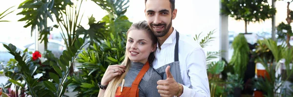 Heureux jeune couple debout dans la boutique de fleurs — Photo