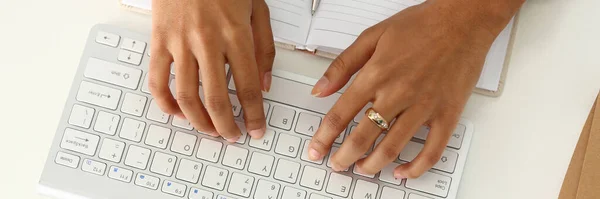 Female hands with ring typing on white keyboard — Stock Photo, Image