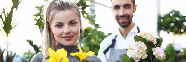 Propriétaires de magasins de fleurs tenant de belles plantes d'intérieur à fleurs — Photo