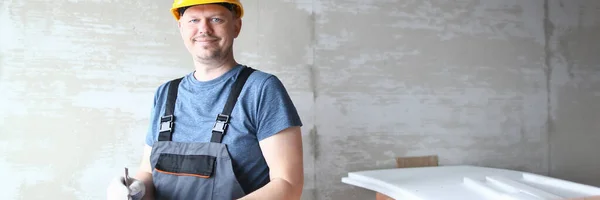 Homem feliz no capacete amarelo apreciando o trabalho na construção — Fotografia de Stock