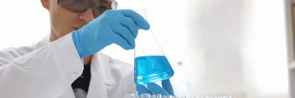 Competent researcher staring at flask with reagent — Stock Photo, Image