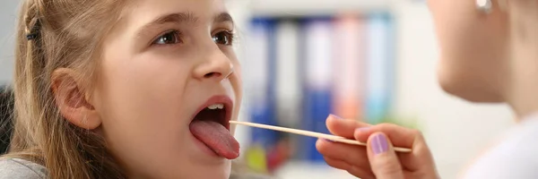 Menina mostrando sua boca para pediatra feminino — Fotografia de Stock