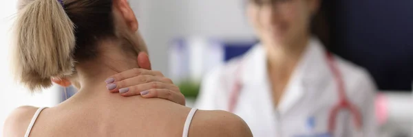 Woman complains of neck pain to doctor. — Stock Photo, Image