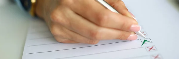 Female hand hold pen in her hand close up and write.