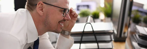 Empresário segurar óculos com a mão e olhar para monitor de computador no local de trabalho. — Fotografia de Stock