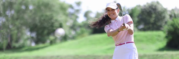 Sonriente mujer caucásica adulta en club de golf golpeando en el retrato de pelota. —  Fotos de Stock