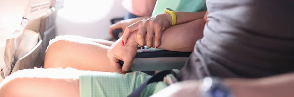 Mujer sostiene firmemente la mano del hombre durante el vuelo en avión — Foto de Stock