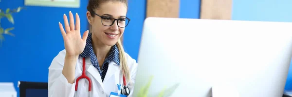 Mujer sonriente médico da la bienvenida a la paciente en línea —  Fotos de Stock